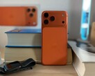 Apple iPhone 17 Air in oranje afwerking met achterontwerp en cameramodule geplaatst op gestapelde boeken