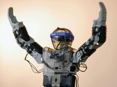Een humanoïde robot met zijn armen in de lucht (Afbeelding bron: Adam Lukomski via Unsplash; bijgesneden)