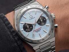 Close-up van de Timex Q Timex Continental Chronograph TW2Y92400 om de pols, met een ijsblauwe radiale wijzerplaat in CD-stijl, zwarte subwijzerplaten, een zilveren tachymeterring en een geïntegreerde roestvrijstalen armband.