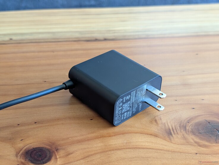 USB-C-netadapter van 65 W die bij de Lenovo Yoga Slim 7 14 wordt geleverd. Let op de niet-intrekbare stekkerpinnen en de geïntegreerde USB-C-kabel aan het andere uiteinde