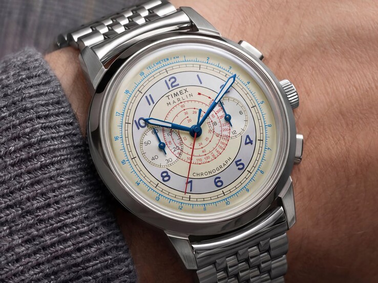 Timex Marlin Neo Classic Chronograph met een crèmekleurige wijzerplaat, blauwe wijzers en een roestvrijstalen armband, gedragen om de pols.