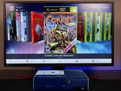 Een gemodde blauwe Xbox 360 met een aangepast homebrew-dashboard op een monitor, waarop het spel "Conker: Live and Reloaded" naast andere Xbox- en emulatortitels. (Afbeelding bron: Modern Vintage Gamer op YouTube)