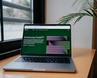 Een laptop op een bureau bij een raam, met de OpenAI ChatGPT-website geopend op het scherm
