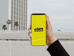 Een hand die een smartphone vasthoudt, met het woord „eSIM“ in grote letters op een geel scherm.