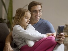 Een vader en zijn dochter die samen naar een smartphone kijken