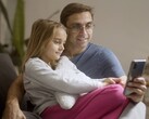 Een vader en zijn dochter die samen naar een smartphone kijken