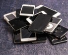 Een stapel afgedankte smartphones op een grijze ondergrond