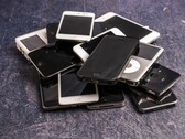 Een stapel afgedankte smartphones op een grijze ondergrond