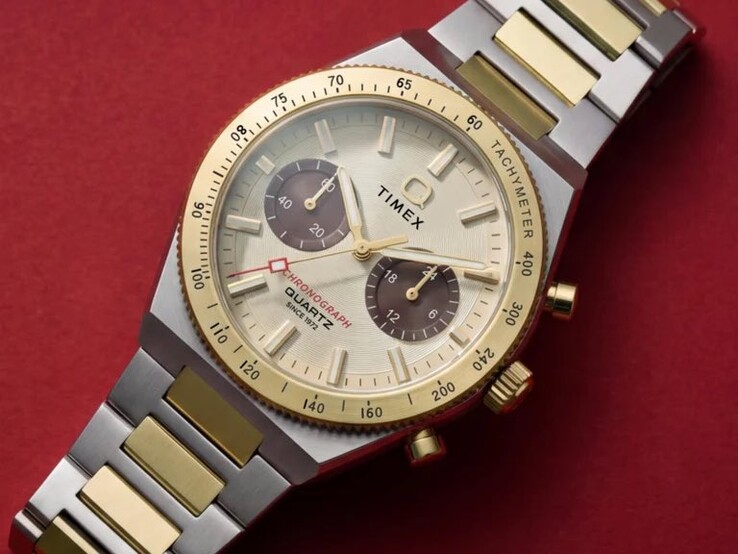 Close-up van de Timex Q Timex Continental Chronograph TW2Y92300 om de pols, met de goudkleurige wijzerplaat, bruine subwijzerplaten, tachymeterring en tweekleurige roestvrijstalen armband.