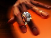 Een persoon die het zilveren Casio CRW-H001M-8 Smart Ring-horloge om zijn vinger draagt, waarbij het compacte digitale display en de metalen constructie goed tot hun recht komen.