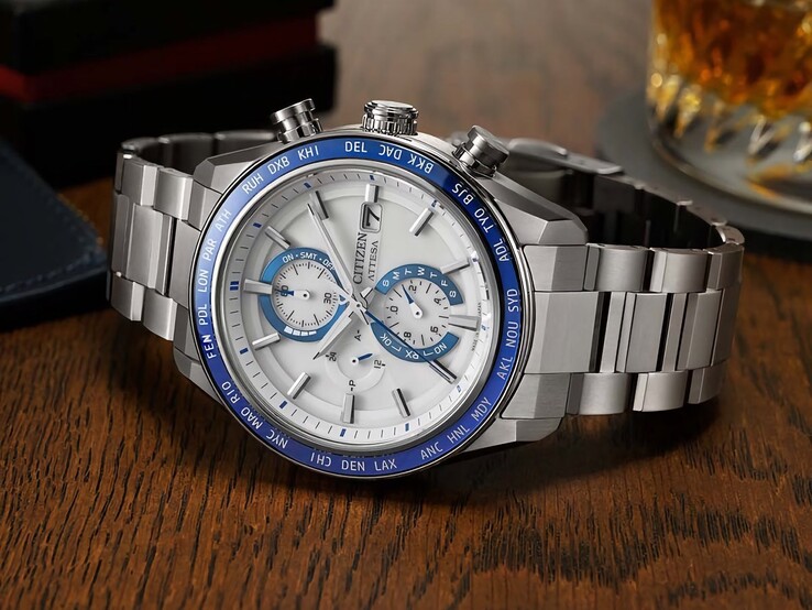 Citizen Attesa AT8297-51L-chronograaf op een houten tafel, met een marineblauwe wijzerplaat, roségouden details en een zwarte bezel voor de wereldtijd.