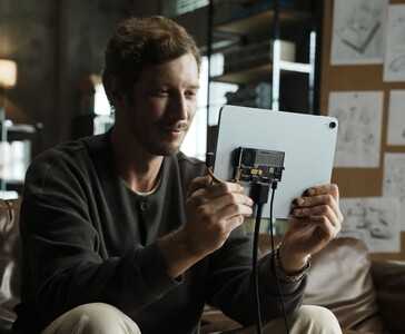 Gebruiker sluit Sharge Disk Pro transparante draagbare SSD met actieve koeling aan op een tablet via USB-C kabel. (Sharge via Kickstarter)