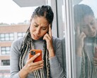 Een vrouw kijkt met een ernstige blik naar haar smartphone