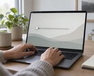 Handen op het toetsenbord van een laptop, een schuifbalk helemaal links op het scherm