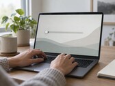 Handen op het toetsenbord van een laptop, een schuifbalk helemaal links op het scherm