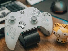 Witte Xbox-controller rustend op een houten bureau naast een klein kattenbeeldje (Beeldbron: FOX ^.ᆽ.^= ∫ via Pexels)