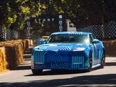 De Jaguar Type 01 EV in de kleur „Blue Exuberant Modernism Camouflage” raast langs de startgrid tijdens de Goodwood Hill Climb