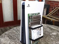 Een PlayStation 5-console naast een op maat gemaakt AMD BC250-bord met een koellichaam en koelventilator. (Afbeeldingsbron: Budget-Builds Official via YouTube)